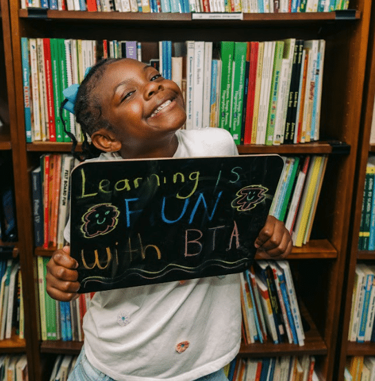 a girl holding a book shelf